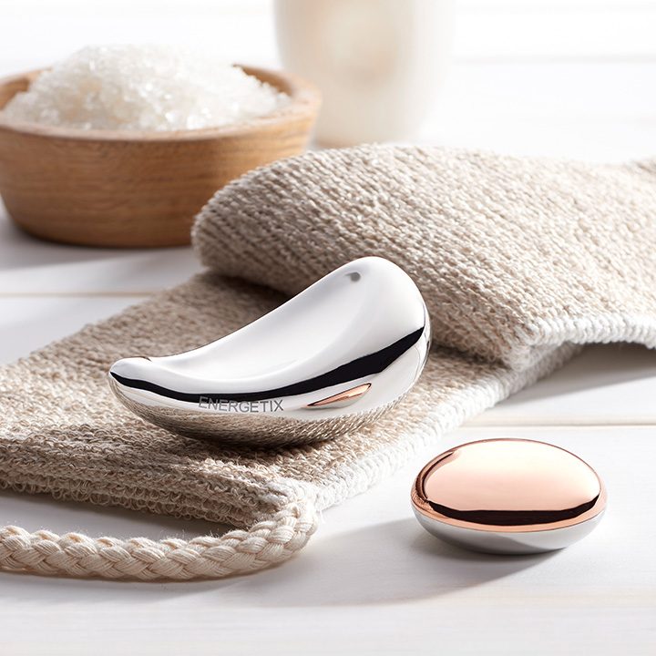 Wellnessartikel Ein glänzendes, modernes Massagegerät in Form eines Vogels auf einem Handtuch.